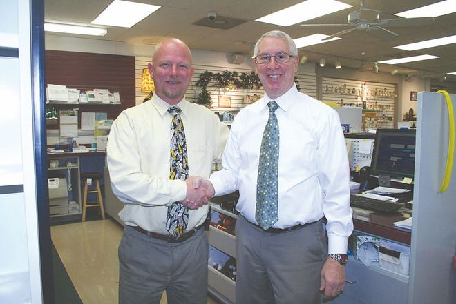 Customers can expect few changes after Rodger Savage, left, acquired Carl’s Drug Store from Frank Ervin.