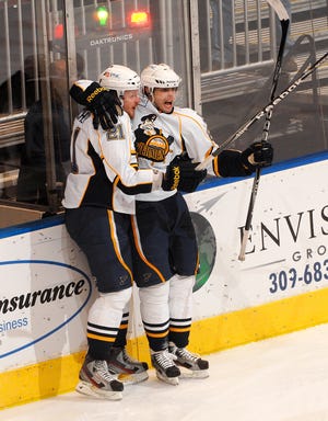 Peoria Rivermen Evgeny Grachev (21), left, and Andrew Murray (28), right, celebrate after Murray scored in the third period of Thursday's game against the Lake Erie Monsters at Carver Arena.