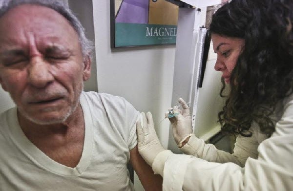 Bebeto Matthews/The Associated Press
Carlos Maisonet, 73, reacts as Dr. Eva Berrios-Colon, a professor at Touro College of Pharmacy, injects him with flu vaccine during a visit to the faculty practice center at Brooklyn Hospital in New York.