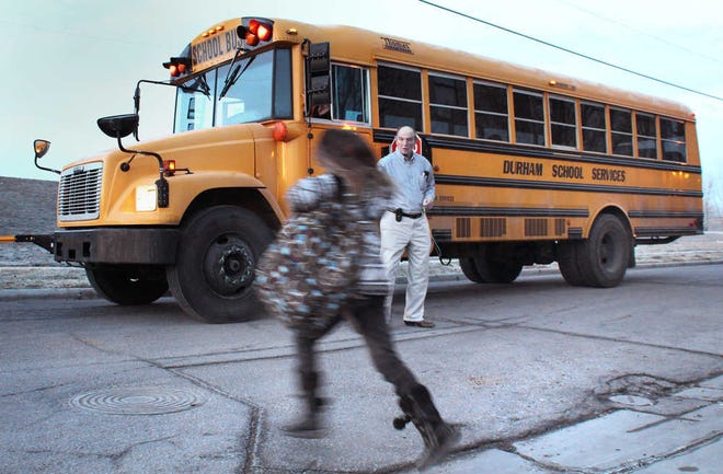 Retired educator Ace Cleavinger helps a student catch a bus to her school outside the Topeka Rescue Mission.