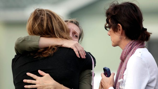 An employee of the nursing home, center, hugs a family member, left, of a resident who was not involved or present at the time of the shooting, shown with the resident's caretaker DeeDee Footer, right, after two people died this afternoon after a reported shooting at Clare Bridge of Tequesta, a nursing home for patients suffering dementia and Alzheimer's, according to a Tequesta Police Department spokesman in Tequesta, Fla., Friday, January 18, 2013. The victims, a husband and a wife, were shot at the home. (Gary Coronado/The Palm Beach Post)