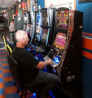 Rich Gabbert, owner of Meadows Avenue Tap in East Peoria, sits behind his video gaming machine.