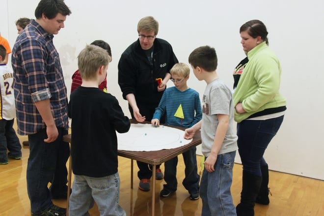 Volunteers from Monmouth College help Cub Scouts play marble games Saturday night at a Warren County YMCA lock-in. Throughout the night, 20 students from Monmouth College volunteered to help the 51 Cub Scouts that were in attendance.