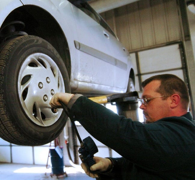 William Simpson of Abeloff Buick GMC Kia of Stroudsburg checks the tire pressure of a Kia Rio, part of a sheduled maintenance including an oil and transmission fluid change and lubrication. Not following a manufacturer’s maintenance schedule can affect warranty coverage.