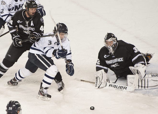 John Carden/Portsmouth Herald photo



University of New Hampshire forward Austin Block, center, chases a loose puck against Providence College goaltender Jon Gillies, right, and defenseman Myles Harvey during Saturday’s Hockey East game at the Whittemore Center in Durham. UNH lost, 6-5.