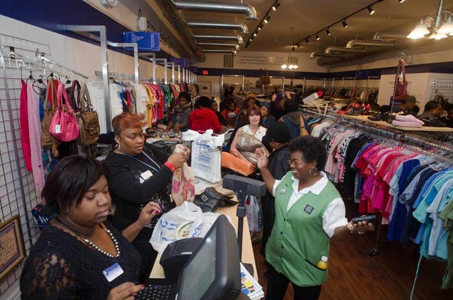 Shoppers check line up with their merchandise at the checkout of the Goodwill Store following the grand opening of its new location at 108 West Broughton Street. johncarringtonphoto.com