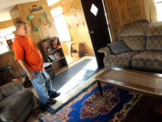 John McGinnis walks through his new home in the Hampstead area Wednesday. McGinnis who was forced by zoning rules to move out of his camper and into a tent now lives in a mobile home on the family land -- thanks to an anonymous donor who was moved by a StarNews story.
