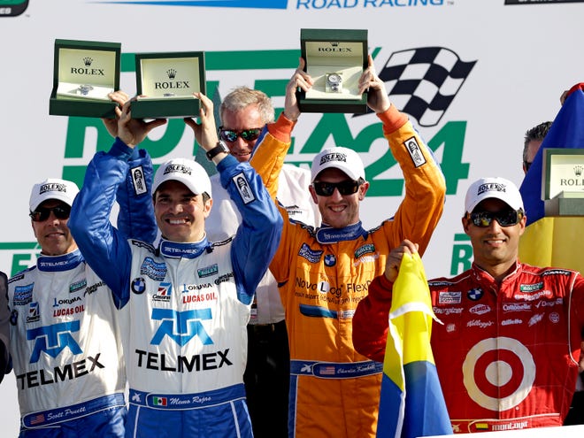 From left, Ganassi Racing team drivers Scott Pruett, Memo Rojas, of Mexico, Charlie Kimball and Juan Pablo Montoya, of Colombia, hold up their Rolex watches given to them for winning the Grand-Am Series Rolex 24 race on Sunday at Daytona International Speedway in Daytona Beach, Fla.