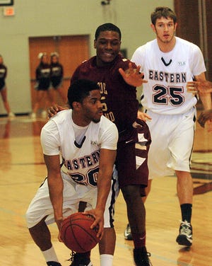 Eastern's Trachone Preston, front, is guarded by RIC's Ethan Gaye, Saturday during their game in Willimantic. At right is Eastern's Tyler Hundley.