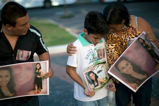 Relatives hold photographs of Pamella Lopes, who died in a nightclub fire, Monday as they stand a public square near the nightclub in Santa Maria, Brazil. A fast-moving fire roared through the crowded, windowless Kiss nightclub in this southern Brazilian city early Sunday, killing more than 230 people. Many of the victims were under 20 years old, including some minors.