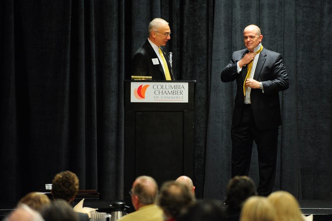 Incoming Columbia Chamber of Commerce President Matt McCormick, right, puts on a Mizzou tie presented by Randy Coil, left, chairman of the  chamber board of directors, during the group’s quarterly membership breakfast Tuesday morning at the Holiday Inn Executive Center. McCormick, who is replacing the retired Don Laird, begins his tenure Monday.
