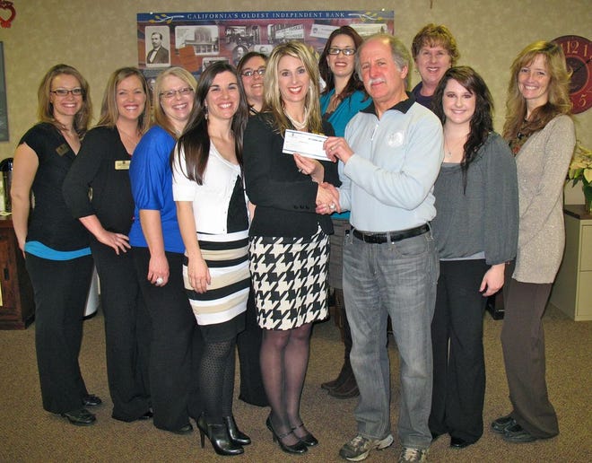 Heather Erickson, Mount Shasta Branch services manager, Scott Valley Bank, gives the awarded check to Jeff Butzlaff, the vice president of Mt. Shasta Sisson Museum. To help celebrate the bank’s long history of providing support for local events are the bank’s staff, from left to right, Erin Koven, Amanda Bonivert, Chris Perriseau, Karley Buhl, Alyssha Silfies, Anna Guzman, Lisa Stevens, Jaycee Sarti and Debra Maghakian.