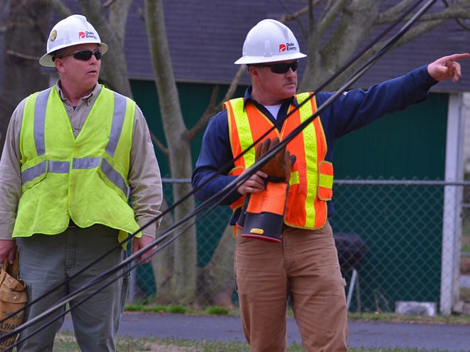 Workers with Duke Energy repair damaged power lines along G Street in Inman Wednesday after two power poles were downed during storms that hit the Upstate.