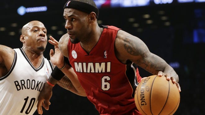 Brooklyn Nets forward Keith Bogans (10) defends as Miami Heat forward LeBron James (6) drives toward the basket in the first half of an NBA basketball game, Wednesday, Jan. 30, 2013, in New York. The Heat won 105-85. (AP Photo/Kathy Willens)