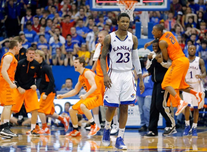 Kansas' Ben McLemore walks off the Allen Fieldhouse court Saturday while Oklahoma State players celebrate their 85-80 win.