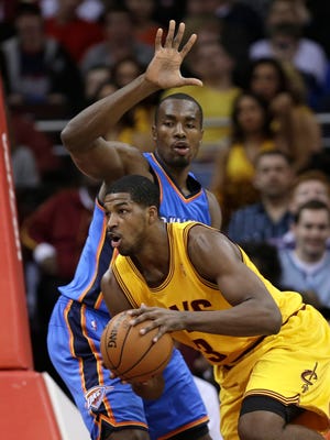 Cleveland Cavaliers' Tristan Thompson, front, drives past Oklahoma City Thunder's Serge Ibaka during the first quarter of an NBA basketball game on Saturday in Cleveland.