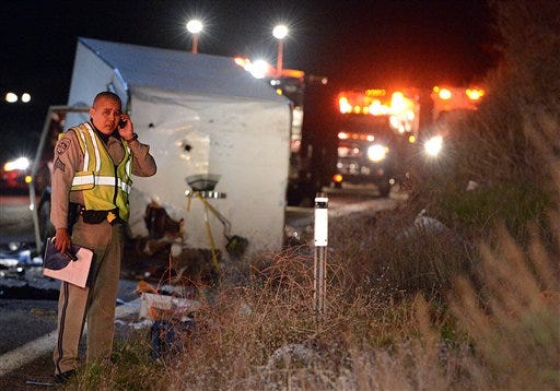 A California Highway Patrol officer stands near the crash scene where at least eight people were killed and nearly two dozen were injured when a bus carrying a group from Tijuana, Mexico crashed with two other vehicles on its way back from Big Bear Lake on Highway 38 north of Yucaipa, Calif., Sunday, Feb. 3, 2013. Both sides of the highway remained closed two and a half hours after the crash and it was unclear when it would reopen.
