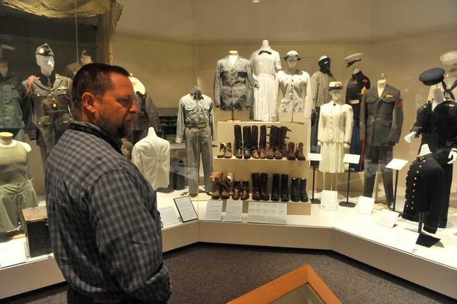 Michael Grauer, Panhandle-Plains Historical Museum's associate director for curatorial affairs and curator of art, opens the museum's latest exhibit of U.S. military uniforms gathered from the museum's permanent collection Wednesday in Canyon. The exhibit displays uniforms from the Civil War up through present day.