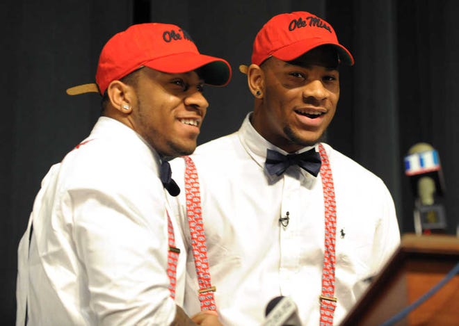 Grayson High School football player Robert Nkemdiche, right, the nation's top recruit, is congratulated by his brother Denzel during Robert Nkemdiche's announcement to play college football for Ole Miss, at a Grayson, Ga., signing ceremony Wednesday Feb. 6, 2013. Denzel Nkemdiche also plays for the Rebels. (AP Photo/David Tulis)