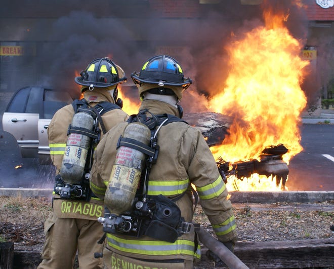 Ocala Fire Rescue firefighters prepare to douse a vehicle that burst into flames along North Pine Avenue on Wednesday. (Photo courtesy of Brian Stoothoff/OFR)