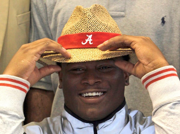 Reuben Foster dons an Alabama hat Wednesday, indicating where he will play college football. (Butch Dill | Associated Press)