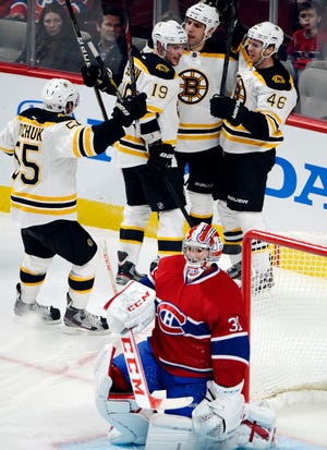 Boston Bruins center David Krejci (46) celebrates with Johnny Boychuk, left,, Tyler Seguin (19) and Milan Lucic after scoring against Montreal Canadiens goalie Carey Price during the third period of their NHL game, Wednesday, Feb. 6, 2013, in Montreal. The Bruins won 2-1.