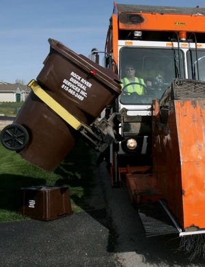 Chuck Keller of Rock River Disposal Services Inc. collects garbage Thursday, March 29, 2012, in the Chicory Ridge subdivision in Roscoe.