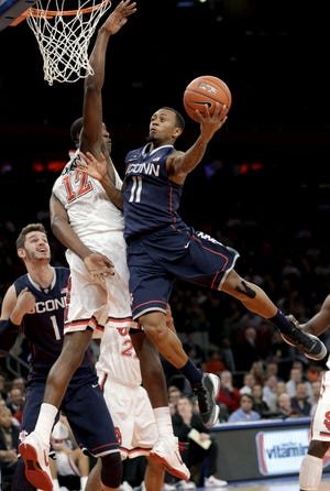 St. John's Chris Obekpa (12) defends as Connecticut guard Ryan Boatright (11) shoots a layup during the first half of their NCAA college basketball game, Wednesday, Feb. 6, 2013, at Madison Square Garden in New York. ()