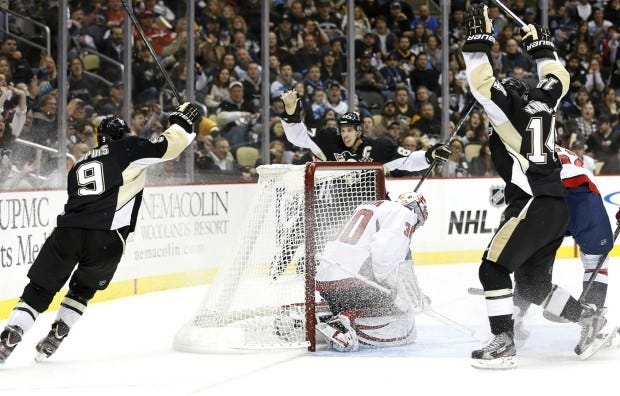Pittsburgh Penguins' Pascal Dupuis (9) celebrates his goal against Washington Capitals goalie Michal Neuvirth (30) with Sidney Crosby, center, and Chris Kunitz (14) in the second period of the NHL hockey game Thursday, Feb. 7, 2013, in Pittsburgh. (AP Photo/Keith Srakocic)