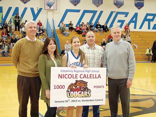 Photo courtesy of Kittatinny High School — Nicole Calella stands at midcourt with her coaches and parents during a celebration in her home gymnasium, after she scored her 1,000th several nights earlier on the road.