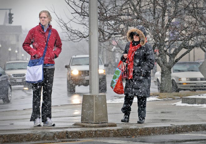 Pedestrians in Quincy Center wait for a red light so they can cross Hancock Street on Friday, Feb. 8, 2013, as the much-anticipated blizzard moves into the region.