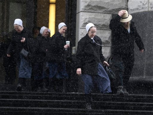 Amish men and women leave the U.S. Federal courthouse Friday, Feb. 8, 2013, in Cleveland. Sam Mullet Sr., 67, the ringleader in a series of unusual hair- and beard-cutting attacks on fellow Amish religious followers in the U.S., was sentenced Friday to 15 years in prison, and 15 family members received sentences of one year to seven years. The defendants were charged with a hate crime because prosecutors believe religious differences brought about the attacks. (AP Photo/Tony Dejak)