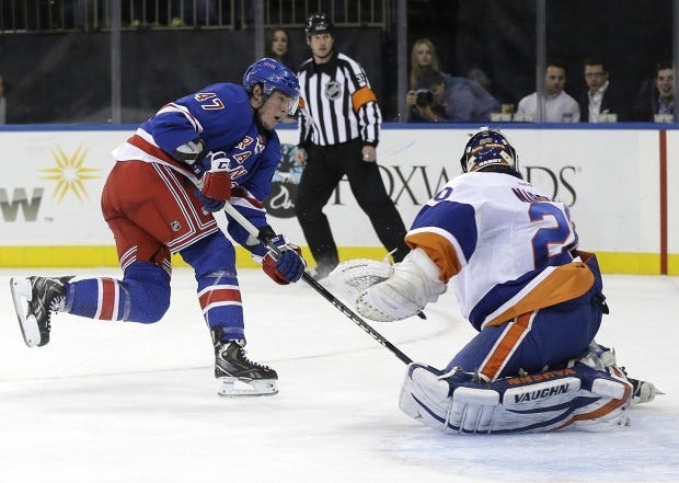 New York Rangers' J.T. Miller, left, scores a goal past New York Islanders goalie Evgeni Nabokov, right, during the second period of the NHL hockey game in New York, Thursday, Feb. 7, 2013. (AP Photo/Seth Wenig)