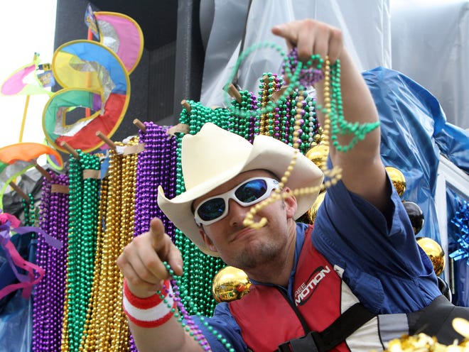 A float rider waves beads to the crowd Sunday as the Krewe of Cleophas rolls through Thibodaux.