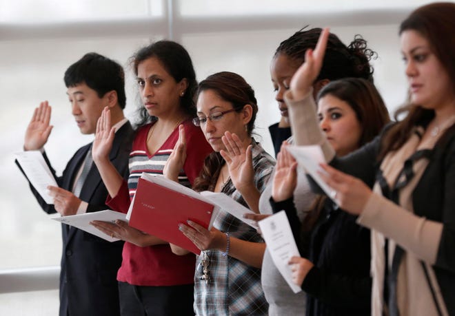Immigrants take the U.S. oath of citizenship during naturalization ceremony Monday, Jan. 28, 2013, in Irving, Texas. (AP Photo/LM Otero)