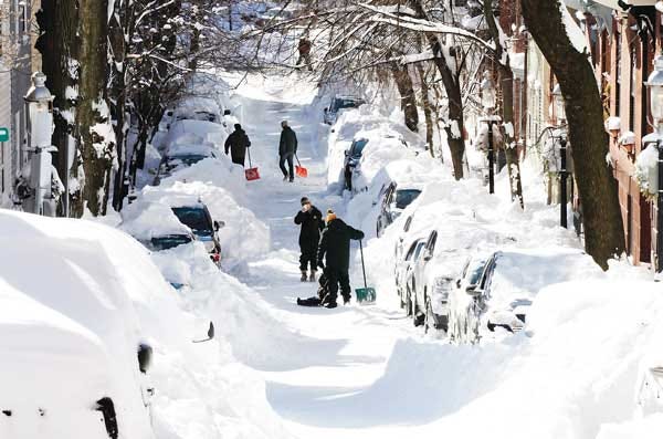 AP Photo/Winslow Townson - People pause for a picture Sunday, Feb. 10, while digging out their cars in Boston. A howling storm across the Northeast left the New York-to-Boston corridor shrouded in 1 to 3 feet of snow Saturday.