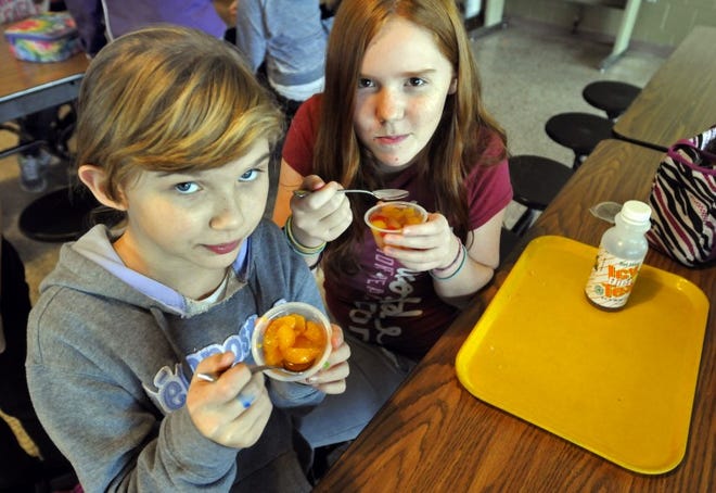 Sixth-graders at Palisades Middle School, Sylvia Pastrone and Carly Weider eat fruit during lunch. Schools now must serve fruits and vegetables with every meal. Art Gentile/Staff photographer