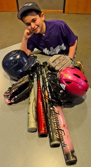 Jeremy Shpigel, 12 from Mount Laurel with donated baseball equipment that has been dropped off atthe Mount Laurel Library to benefit the non-profit Pitch in for Baseball.