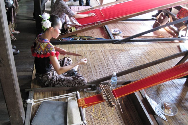 An Iban weaver works on the textiles at Sarawak Cultural Village.