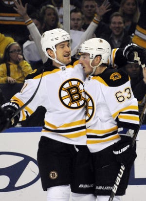 Bruins forward Brad Marchand (right) celebrates with defenseman Andrew Ference after scoring a goal during the second period of Boston's 3-1 win over the Sabres on Sunday night. Gary Wiepert/The Associated Press