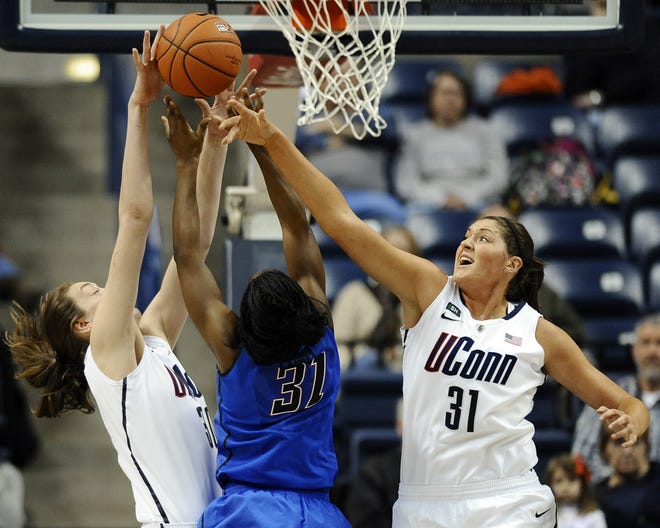 Connecticut's Breanna Stewart, left blocks a shot attempt by DePaul's Jasmine Penny, center, as Connecticut's Stefanie Dolson, right, defends during the first half of an NCAA college basketball game in Storrs, Conn., Sunday, Feb. 10, 2013. (AP Photo/Jessica Hill)