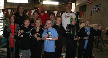 Atomic City Aquatic Club winners during the Lois Weir Invitational show off their trophies. Winners include, from left in front, Tanner Alexander, Carly Wrobleski, Mason Fischer, Jake Mason, Colby Maupin, Alton Alexander and Vidar Hondorf; middle row from left, coach Kendahl McMahon and Cameron Holcomb; inback from left, coach Breona Moyers, coach Mike Bowman and coach Lars Hondorf.