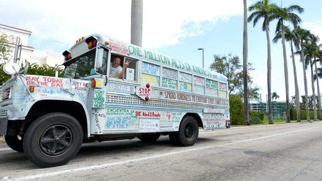 Bob Votruba drives his bus along Royal Palm Way Tuesday morning. Votruba is driving around the perimeter of the United States and riding his bicycle in different towns to raise awareness for bullying and adolescent suicide.