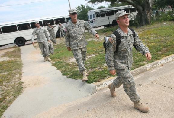 Members of the 505th National Guard Unit leave buses to greet their family at Fort Bragg near Fayetteville on Saturday, Sept. 23, 2006. (Halifax Media Group file photo)