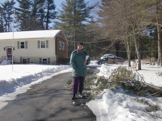 Betty Lyden, of Orchard Street in Raynham, stands in front of her home, which still did not have power on Wednesday after the blizzard battered the region over the weekend.