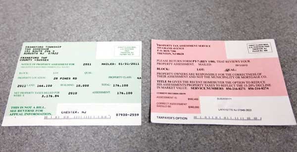 Photo by Tracy Klimek/New Jersey Herald A real green tax assessment card, left, and a pink advertisement card sit on the counter in the Sussex County Board of Taxation office in Newton on Thursday.