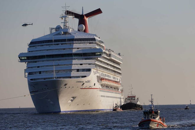 The cruise ship Carnival Triumph is towed Thursday into Mobile Bay near Dauphin Island, Ala. The ship with more than 4,200 passengers and crew members has been idled for nearly a week in the Gulf of Mexico following an engine room fire. The ship arrived at a terminal in Mobile, Ala., late Thursday night.