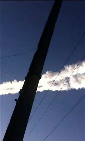 In this photo taken with a mobile phone camera, a meteorite contrail is seen in Chelyabinsk region on Friday, Feb. 15, 2013. A meteor streaked across the sky of Russia?s Ural Mountains on Friday morning, causing sharp explosions and reportedly injuring around 100 people, including many hurt by broken glass.