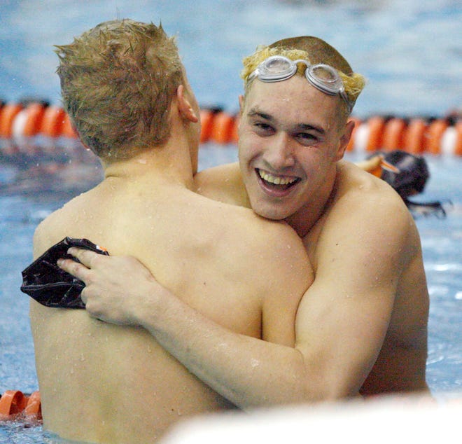 Byron’s Aaron Helander (right) and Auburn’s Joe Johnson celebrate their first- and second-place (respectively) finishes in the 100-yard butterfly in the boys swimming sectional Saturday, Feb. 16, 2013, at Byron High School. Both qualified for state.