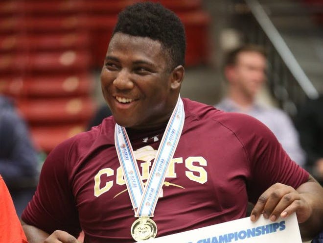 Aaron Pringle of North Marion is presented with the 285lb 1A State Wrestling Championship medal at the FHSAA State Wrestling Championship at the Lakeland Center on Saturday.